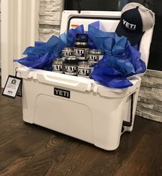 a cooler filled with cans of beer on top of a hard wood floor