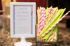 there are many straws in a glass next to a sign