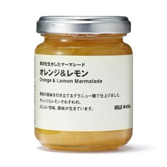 a jar of orange and lemon marmalade with japanese writing on the lid, in front of a white background