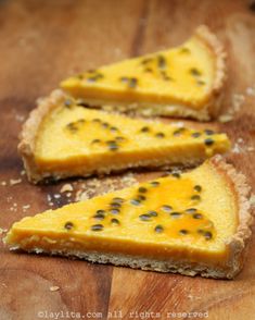 three slices of cheesecake on a wooden cutting board with black pepper sprinkles