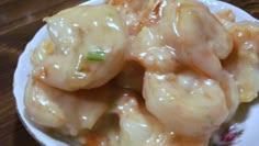 a white plate topped with dumplings covered in sauce