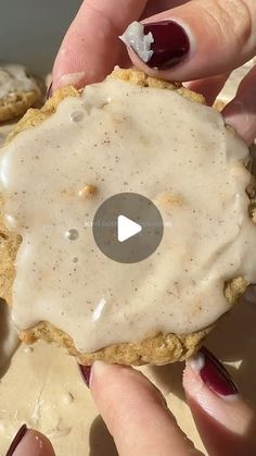 a person holding a cookie with icing on it