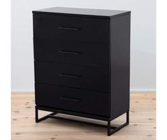 a black chest of drawers sitting on top of a wooden floor