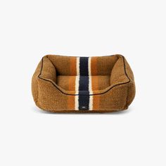 a brown dog bed with blue, white and orange stripes on the bottom half of it