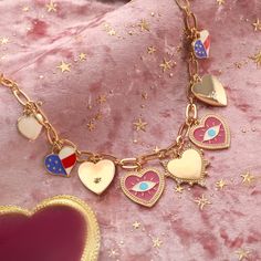 Immerse yourself in the eccentric charm of the Heart Evil Eye Charm Necklace, a standout piece from our "Powerful and Unconstrained Style" collection, straight out of a scene from a whimsical period piece. Picture this: an exquisite heart-shaped pendant, rendered in 18K gold-plated brass, is adorned with a bewitching evil eye motif. The necklace is meticulously detailed with a cascade of dripping oil and a sprinkling of cubic zirconia, adding a dash of cinematic sparkle. This charm necklace is n Valentine's Day Symbolic Necklaces With Heart Pendant, Symbolic Heart Charm Necklace For Valentine's Day, Symbolic Heart-shaped Charms Jewelry, Symbolic Heart-shaped Jewelry With Charms, Valentine's Day Heart Pendant Charm Necklaces, Valentine's Day Symbolic Jewelry With Heart Charm, Valentine's Day Heart Charm Symbolic Jewelry, Valentine's Day Symbolic Heart-shaped Jewelry, Pink Heart Necklace With Dangling Charms