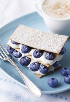 a blue plate topped with food next to a cup of coffee