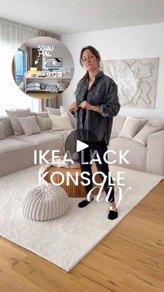 a woman standing in front of a living room filled with furniture and decor on top of a hard wood floor