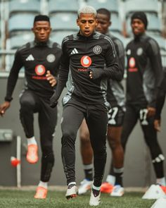 the soccer players are warming up before their match against each other in black and grey uniforms