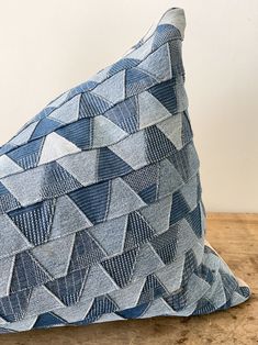 a blue and white pillow sitting on top of a wooden table