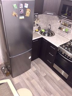 a small kitchen with stainless steel appliances and wood flooring is pictured in this image