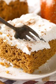 a piece of cake with frosting and a fork in it on a white plate