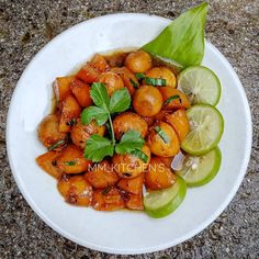 a white plate topped with oranges and cucumbers next to lime wedges