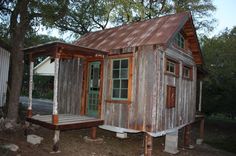 a small wooden cabin sitting next to a tree