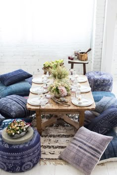 a table with blue pillows and plates on it