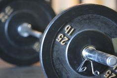 the barbells are close to each other in this gym setting, with numbers on them