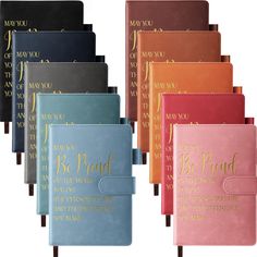 six different colored notebooks with gold lettering on them