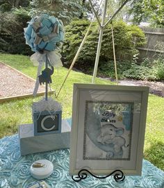 an elephant themed baby shower is set up on a table in front of the yard