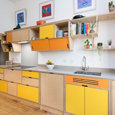 an orange and yellow kitchen with wooden cabinets