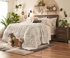 a bed room with a neatly made bed and lots of plants