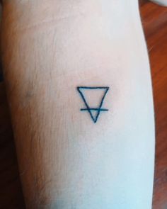 a person with a tattoo on their arm that has a triangle in the middle of it