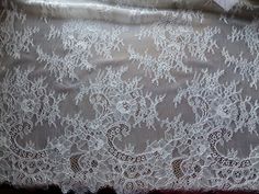 the white lace has been placed on top of the bed sheet and is ready to be sewn