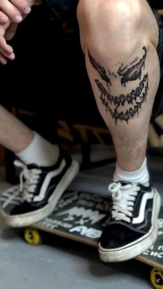 a man sitting on top of a skateboard next to another person's legs