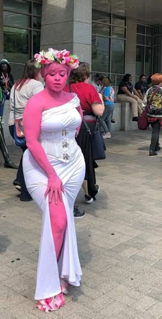 a woman dressed in pink and white poses for the camera with her arms around her body