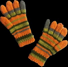 two orange and green knitted mittens sitting next to each other on a black background