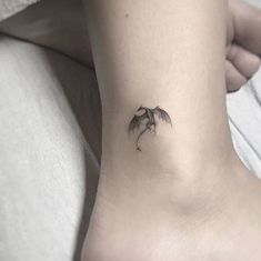 a small palm tree tattoo on the left side of the ankle is shown in black ink