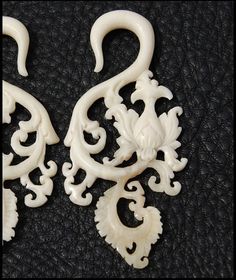 pair of white carved earrings on black background