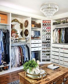 an organized closet with clothes, shoes and other items on shelves next to a coffee table