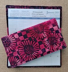 a pink and black calendar with flowers on it