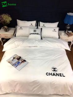 a bed with chanel pillows and pictures on the comforter in front of it