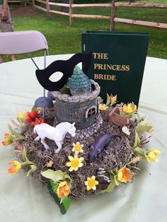 a table topped with a fake horse statue next to a princess's bride book