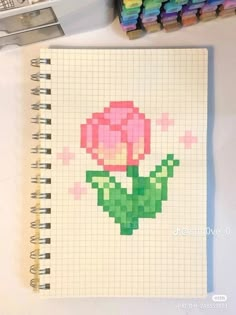 a notebook with a flower drawn on it next to markers and crayon pens