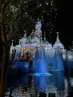 an illuminated castle in the middle of a lake