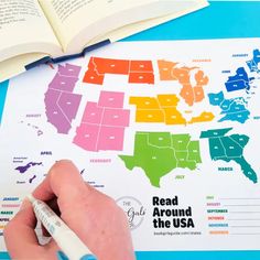 a person is writing on a map with the united states labeled in rainbows and colors