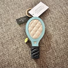 a keychain that has a small mirror on it with a tag attached to it