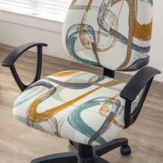 an office chair with a colorful print upholstered on the back and arms, sitting in front of a window