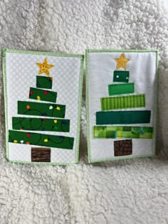 two green christmas tree pillows on a white blanket