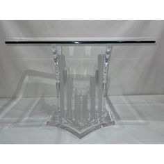 a clear glass table with an intricate design on the top and bottom, sitting on a white background