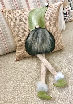 a green gnome pillow sitting on top of a couch