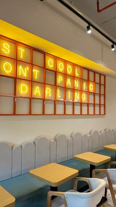 an empty restaurant with chairs and neon signs on the wall above it's windows