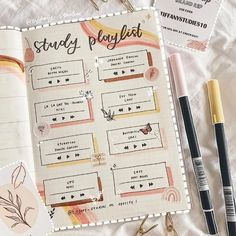 an open planner with pens, scissors and other items next to it on a bed