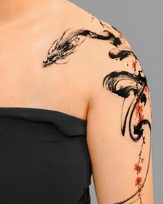 a woman's arm with an artistic tattoo design on her left shoulder and chest