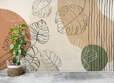 a potted plant sitting on top of a cement floor next to a wall mural