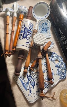 an assortment of kitchen utensils are on a table with a white and blue cloth