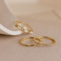 two gold rings sitting on top of a table