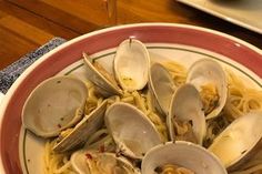 a plate of pasta with clams and an apple