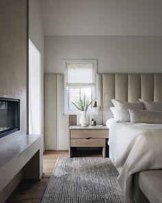 a bedroom with a bed, nightstand and window